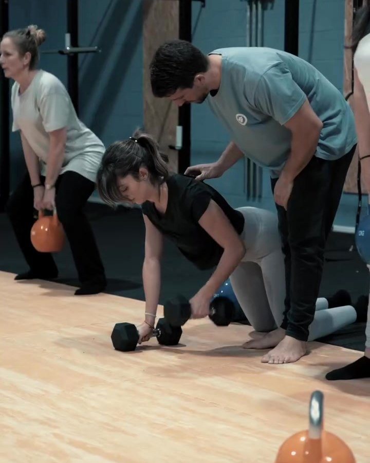 Entrenador corrigiendo la técnica de una socia